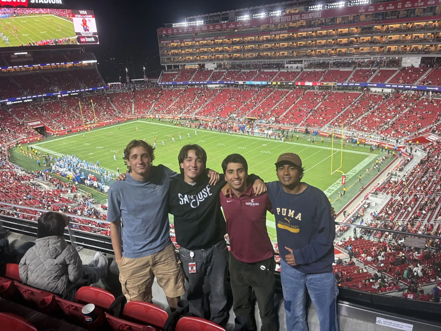 Friends watching a football game from the stadium stands