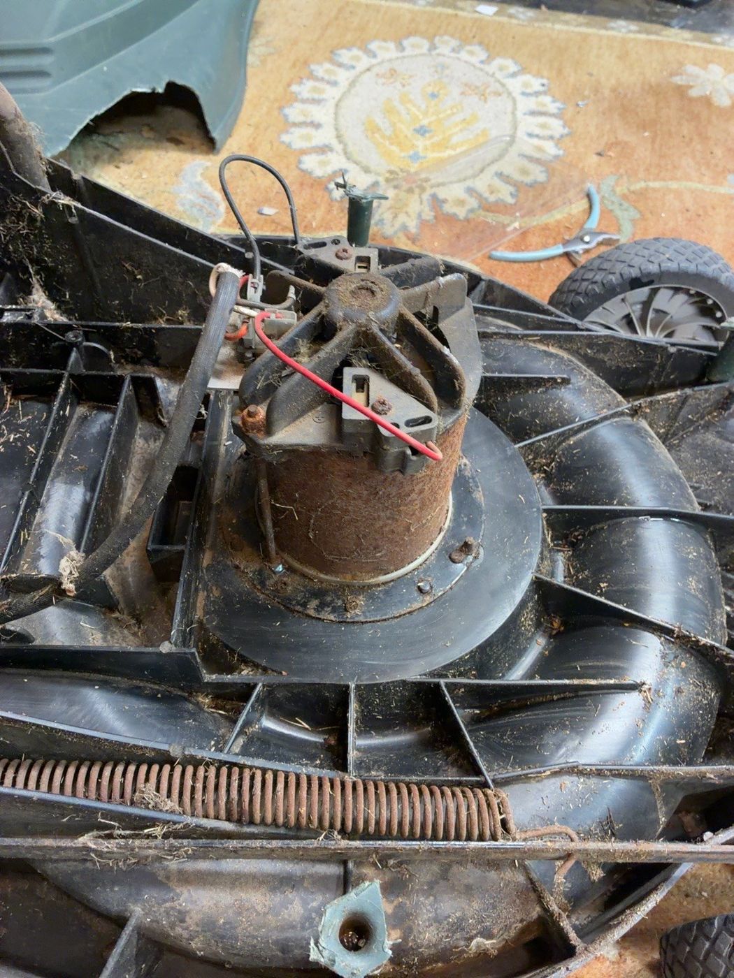 Exposed central blade motor and wiring inside the mower