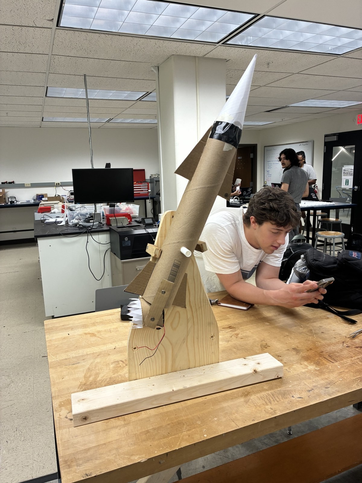 Early rocket mockup on a wooden support frame in the studio